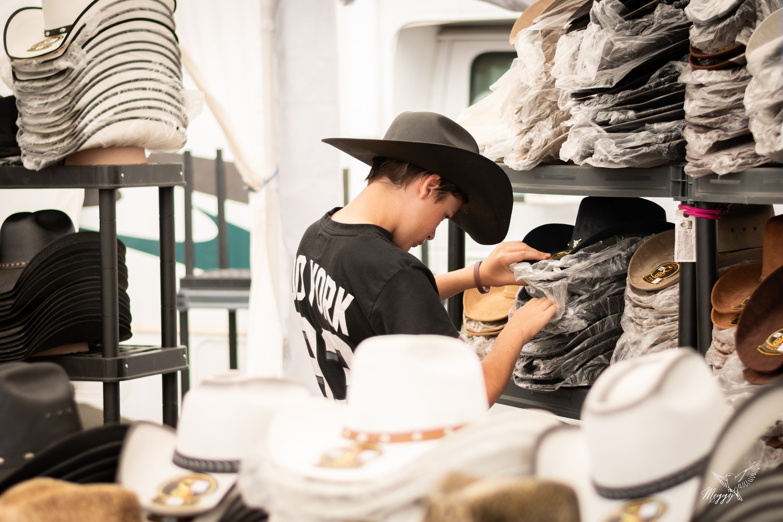 Un visiteur regarde les chapeaux proposés dans une boutique du Festival en 2025.