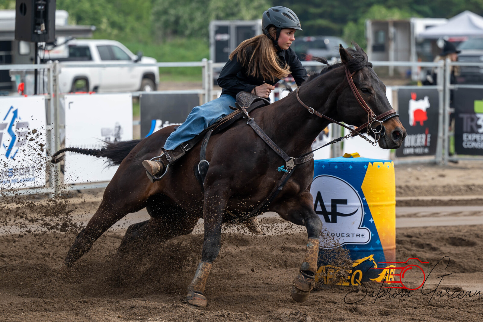 Une personne casquée à cheval contourne un baril bleu et jaune pendant le Festival en 2025.