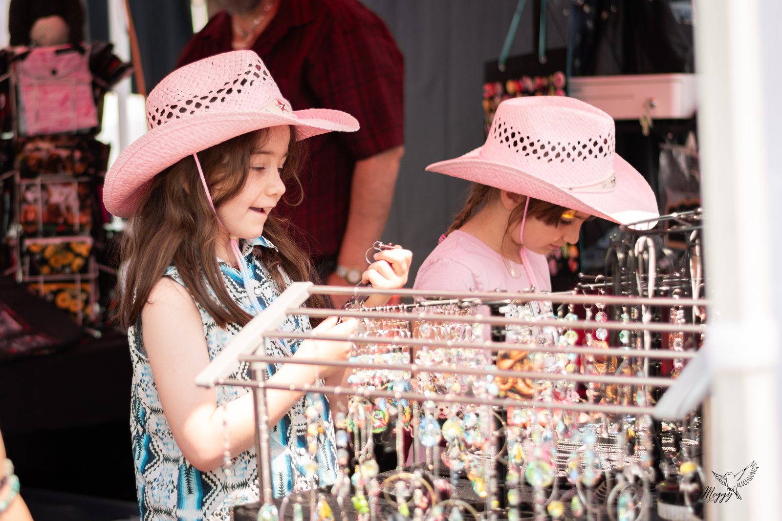 Deux enfants découvrent les bijoux et accessoires proposés dans un kiosque du Festival.