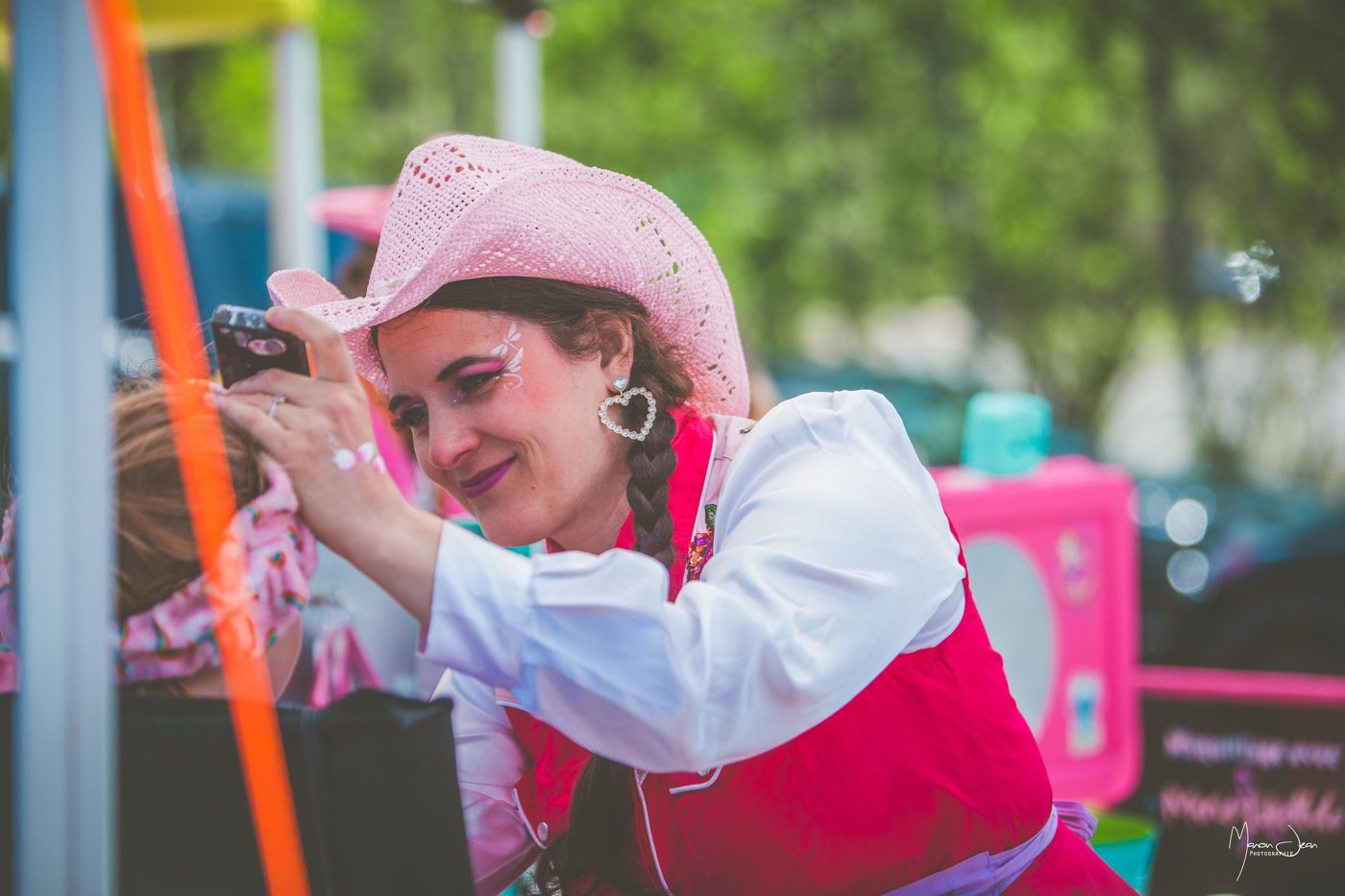Une maquilleuse souriante anime un atelier pour les enfants au Festival.