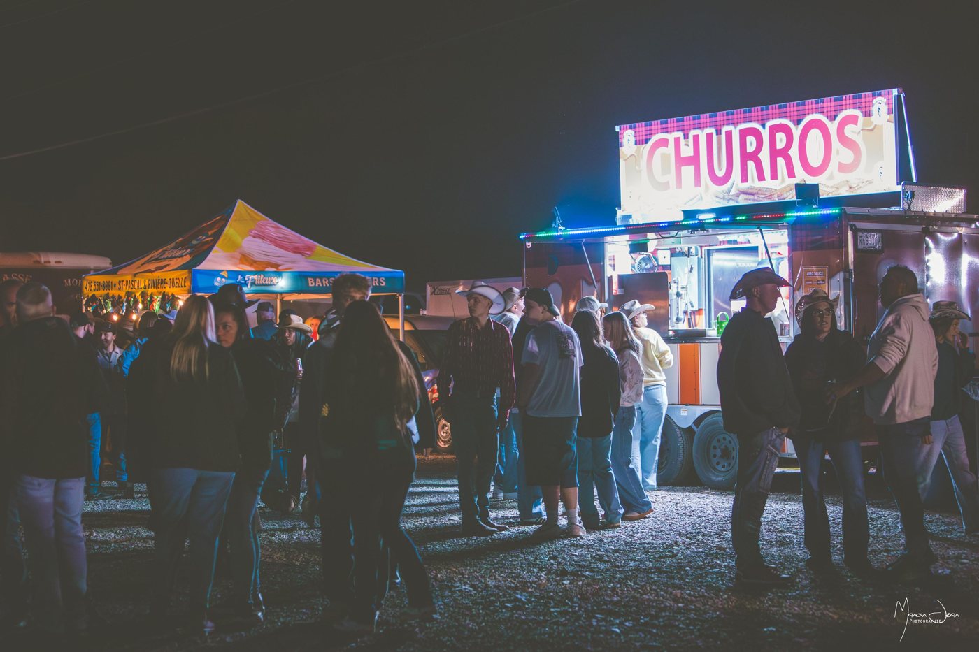 Les visiteurs profitent des comptoirs gourmands illuminés en soirée.